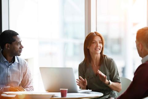 Three people sitting at a desk